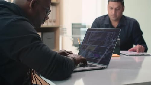 Adults Working Together on Laptops in Modern Office