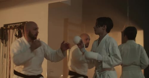 Karate Master Blocks Attacks of Boy Student Near Mirror in Gym