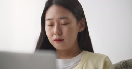 Woman Uses Laptop Computer While Relaxing at Home