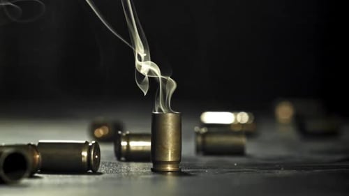 Smoldering Bullet Casing Surrounded by Spent Brass