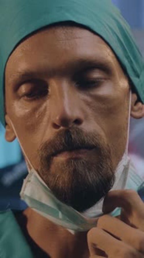 Tired doctor takes mask down in hospital