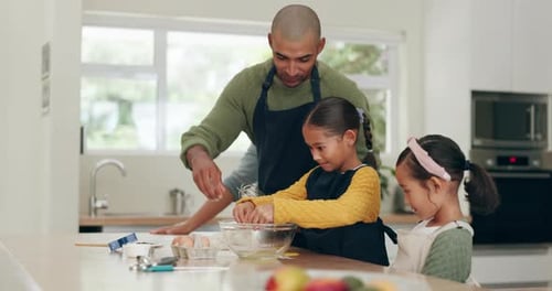 Father and Daughters Baking Together in Kitchen