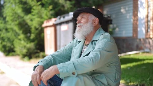 Frustrated Old Caucasian Man Sitting on Road Curb Looking Around in Slow Motion