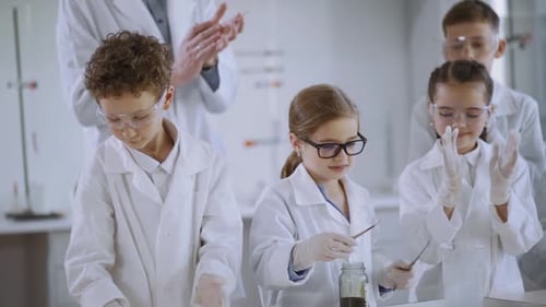 Children in Lab Coats Conduct Science Experiment