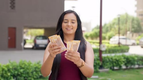 Woman Counting Money Outdoors on Sunny Day