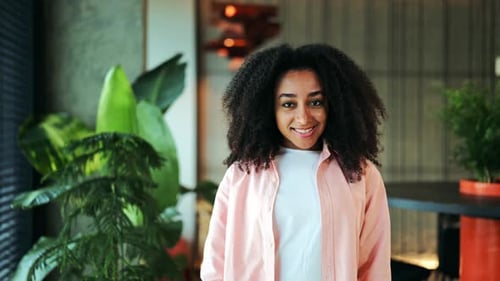 Smiling Woman with Curly Hair Winking Indoors