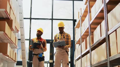 Two Men Working with Laptop and Clipboard Lists