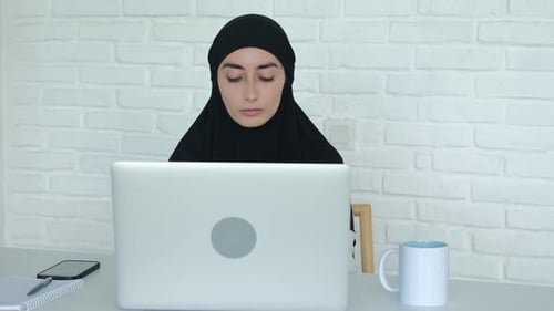 Muslim Business Woman Works in the Office at the Computer