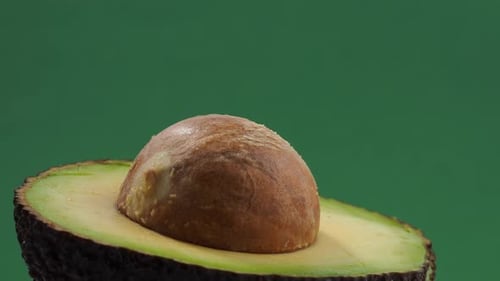 Rotating avocados on a green background.