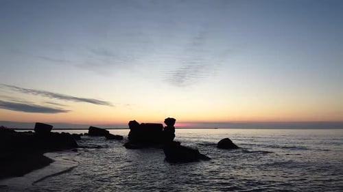 Beautiful vibrant high contrast sunset low altitude flyover over the Karosta war port concrete coast