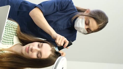 Woman Receiving Hair Exam by Medical Professional