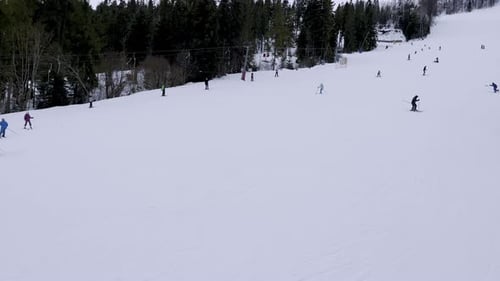 Skiers Skiing Downhill in Winter Resort Mountains Skiers and Snowboarders Riding Down the Hill