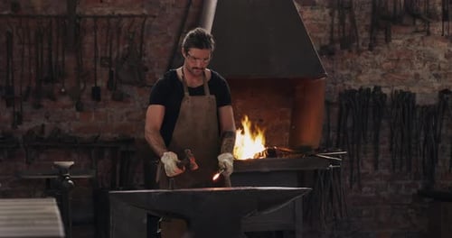 Sparks, blacksmith and man with hammer on anvil in workshop for forging iron, steel or metal