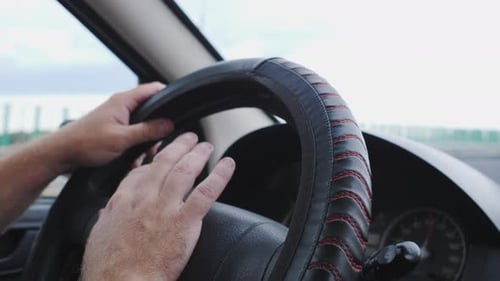 Man's Hands Steering Wheel of a Car