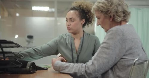 Female Doctor giving SeniorPatient Pills in Doctors Office