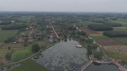 View Of A Serene Landscape With A Large Pond And Surrounding Greenery
