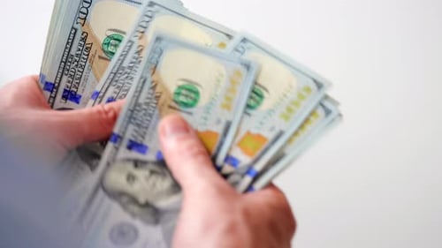 Männliche Hände zählen US-Dollar-Scheine in Nahaufnahme
