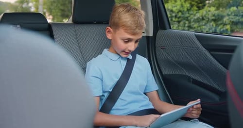 Enfant voyageant en mode automatique partageant une tablette de jeu portable.