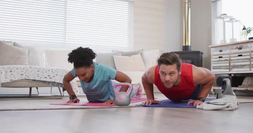 Couple Doing Pushups Together in Living Room
