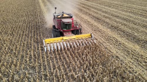 Drone flyover a vast agricultural farm fields capturing aerial view of a combine harvester in action