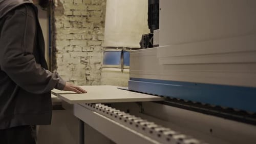Man operating a machine in a woodworking factory