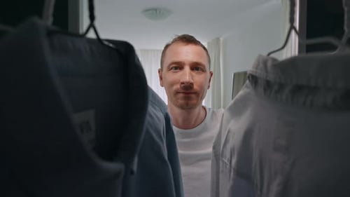 Man Standing in Closet Selecting a Shirt