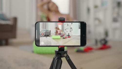 Tutorial de grabación de yoga para mujer con teléfono inteligente en un estudio doméstico, transmisión de acondicionamiento físico femenino