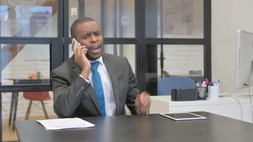 Man Arguing on Phone in Office Setting