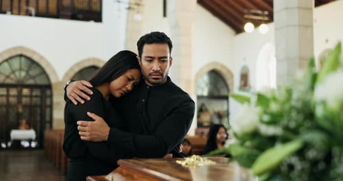 Death, loss or couple at funeral by coffin, mourning or man to comfort woman for dead family
