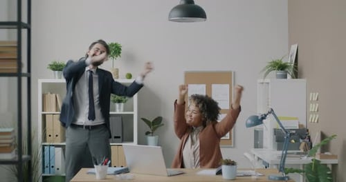 Colleagues Middle Eastern Man and African American Woman Dancing Having Fun in Modern Office