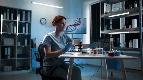 Scientist Using Microscope and Test Tubes in Lab