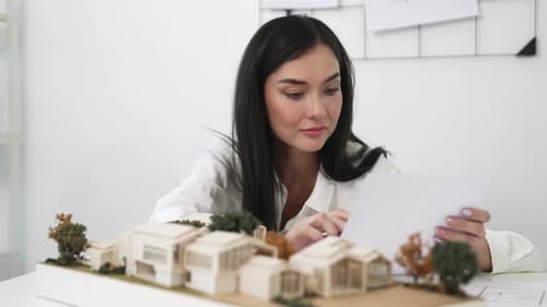 Closeup of beautiful architect measure the architectural model. Immaculate.