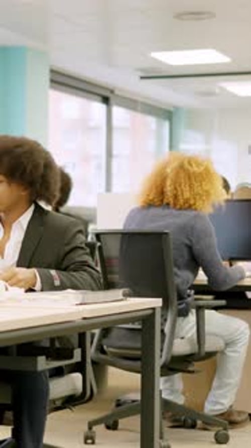 Collègues multiethniques travaillant avec des ordinateurs sur des bureaux