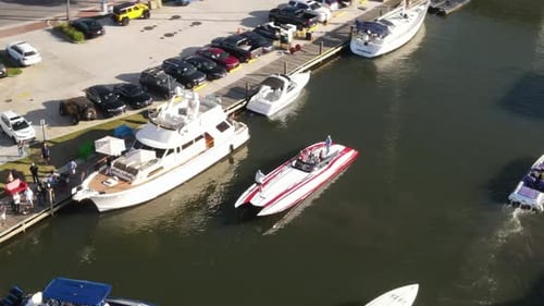 Aerial View Of People In Powerboat Next To A Luxury Yacht In The Marina. - pullback