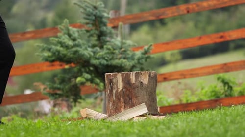 Slow Motion Of A Man Picking Up Axe To Chop Wood In The Yard. medium shot