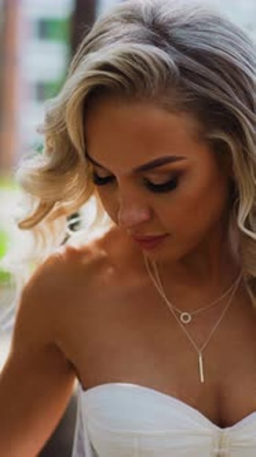 Attractive Lady Bride in Wedding Dress Stands in Green Park