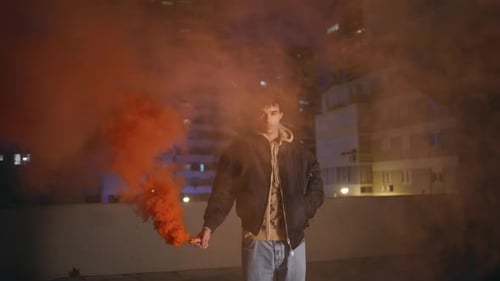 Young Adult with an Orange Smoke Flare at Night