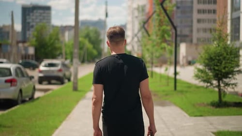 Young White Tourist Walking City Sidewalk with Duffel Exploring Neighborhood Sunny Weather Modern