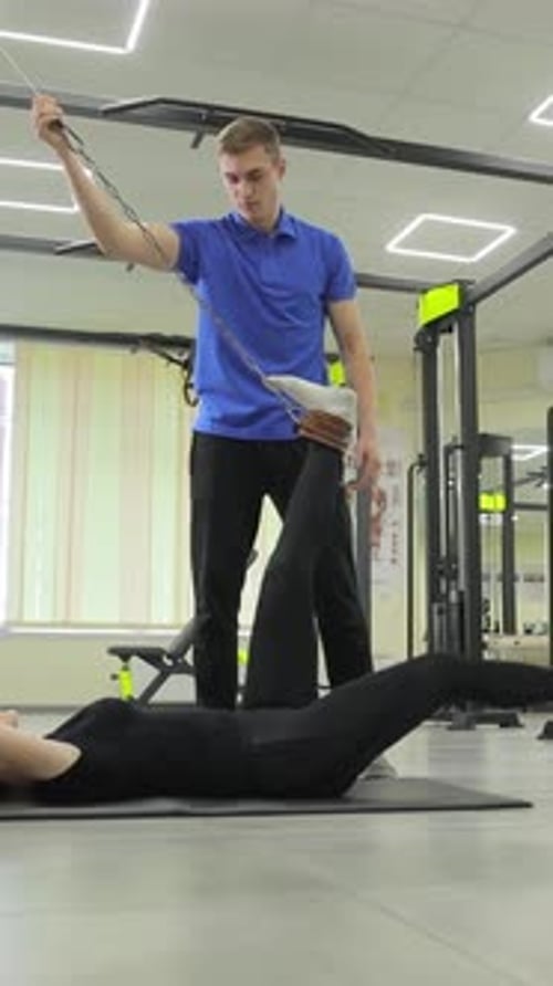 Woman Doing Leg Exercise with Personal Trainer