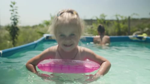 Mutter mit Kindern badet im Pool auf dem Gelände eines Landhauses