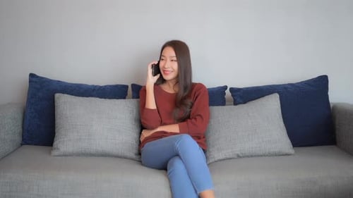 Woman Chatting on Phone While Relaxing on Sofa