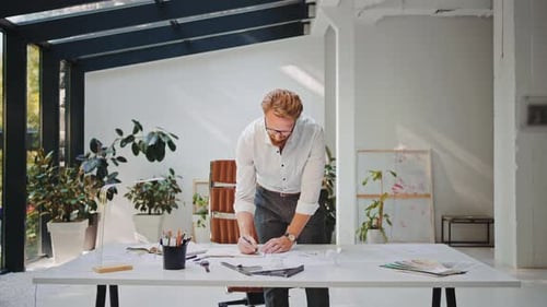 Professioneller Erwachsener, der sich im Designstudio Notizen auf Papier macht