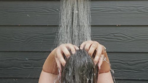 Person Washing Dark Hair in Shower