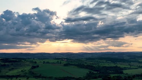 Scenic Green Landscape with Radiant Sunbeams at Sunset