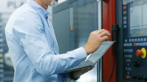 Chefingenieur/ Bedienerprogramme/ richtet CNC-Maschine mit Bedienfeld ein. Er arbeitet am Modern T