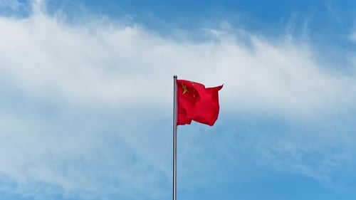 China Flag Waving Against a Bright Blue Sky