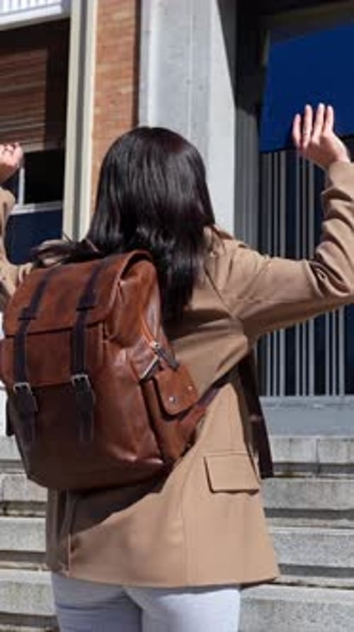 Feliz estudiante universitario que celebra el éxito del examen en las escaleras del campus