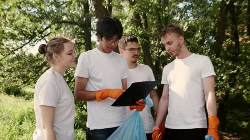 Young Eco Volunteers Team Doing Distribution of Duties for Forest Cleanup Plan Standing at the Glade