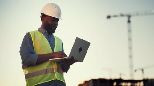 Moderne Technologie und Software für Architekten und Bauherren Black Man with Laptop Inspector oder Auditor