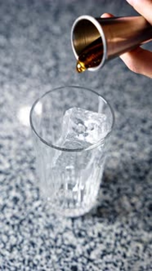 Cocktail Ingredient Being Added to a Glass